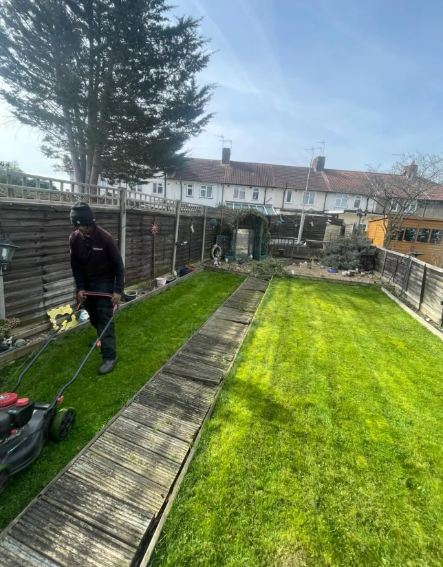 Greenline operative mowing a rear lawn